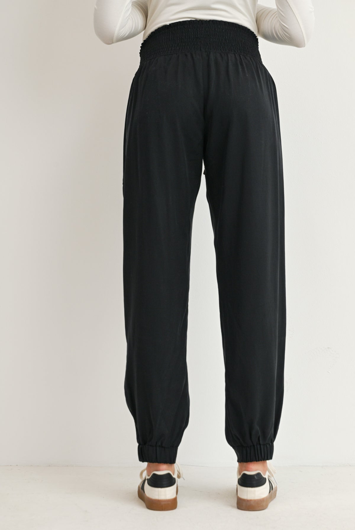 Black maternity smocked waist jogger pants with elastic cuffs back view
