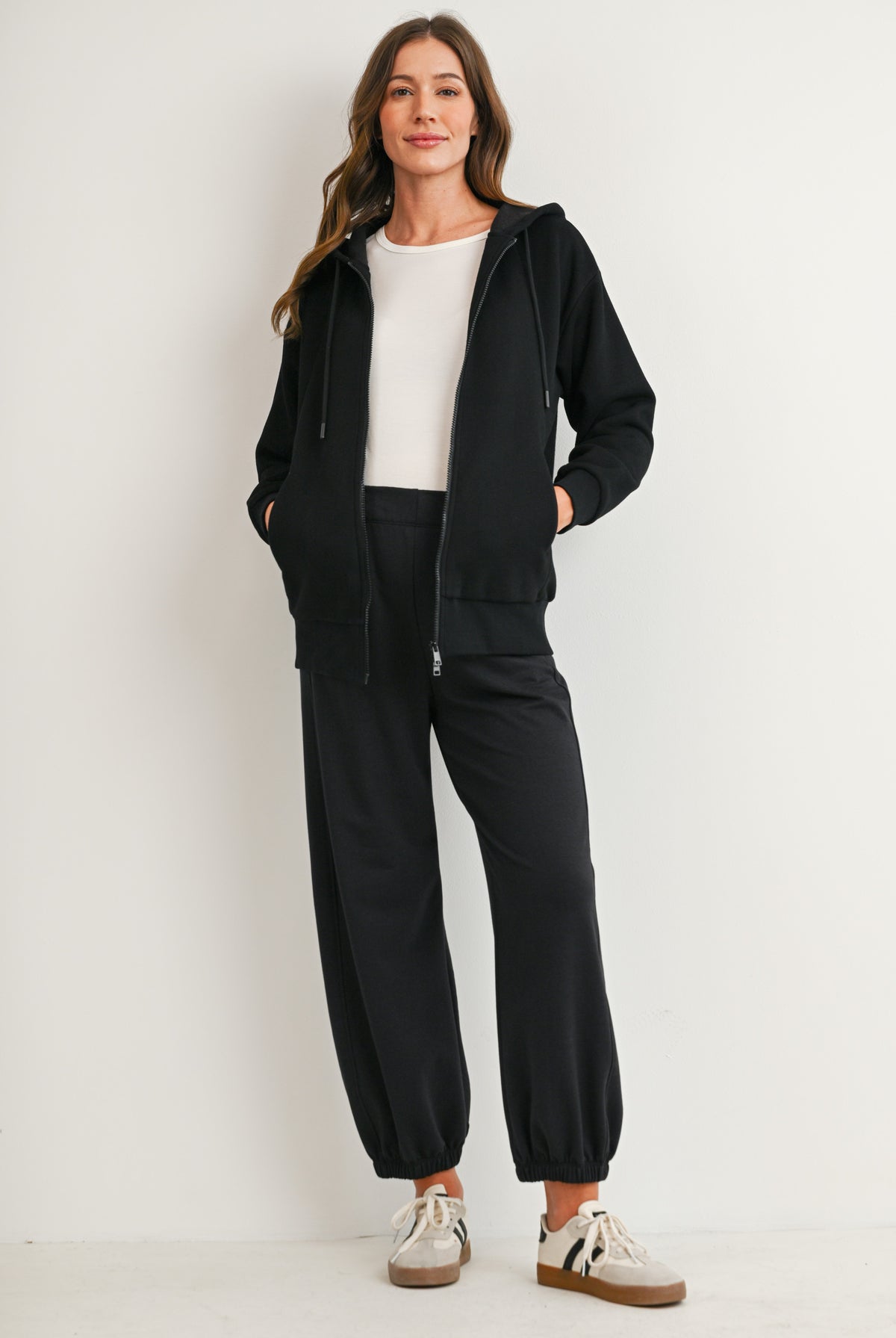 Full body view of black full-zip maternity hoodie with pockets and drawstring hood