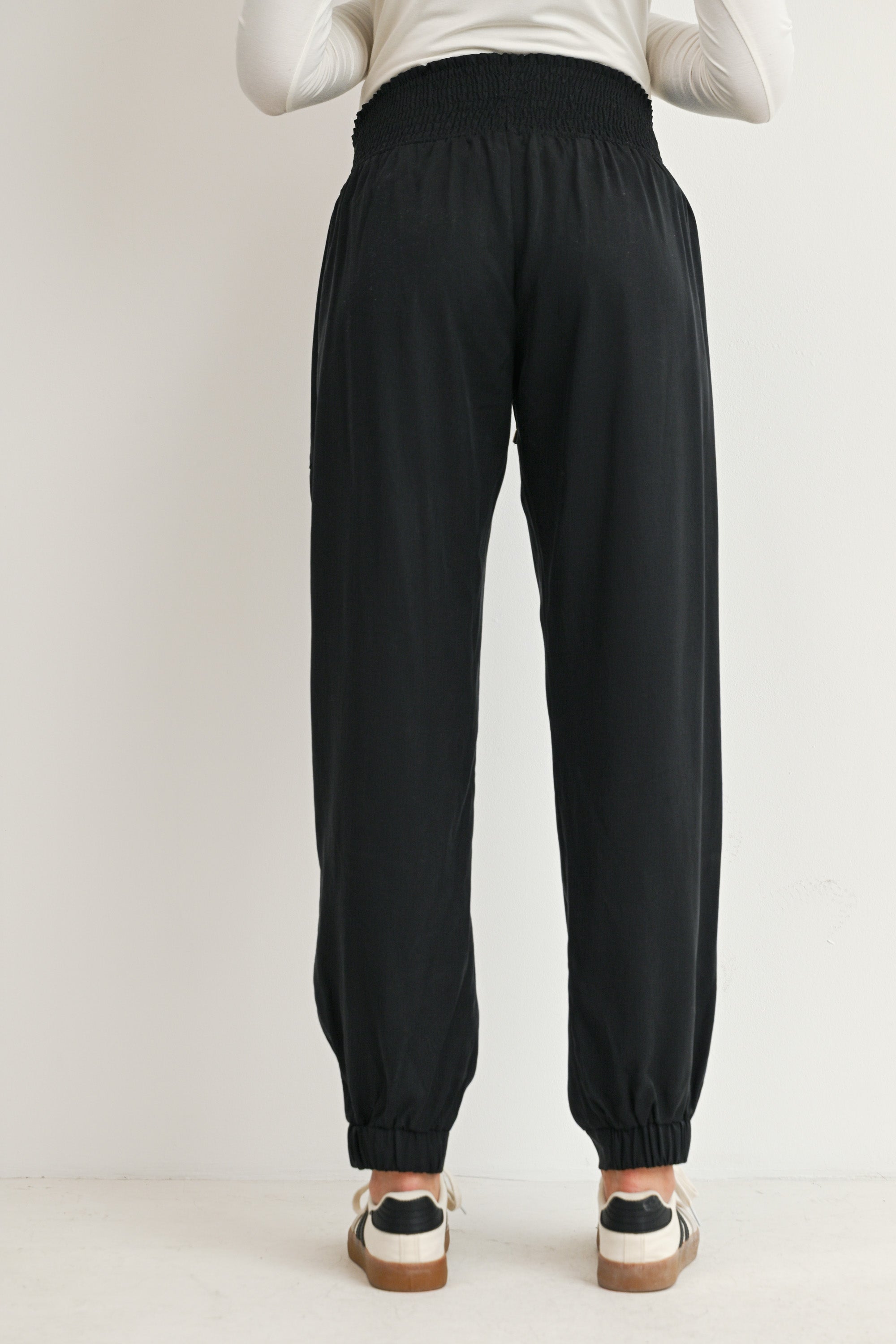 Black maternity smocked waist jogger pants with elastic cuffs back view