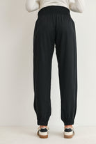 Black maternity smocked waist jogger pants with elastic cuffs back view