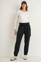 Black maternity tapered jogger pants with smocked waist and elastic cuffs