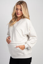 Side view of Hello Miz maternity nursing sweatshirt in oatmeal with kangaroo pocket