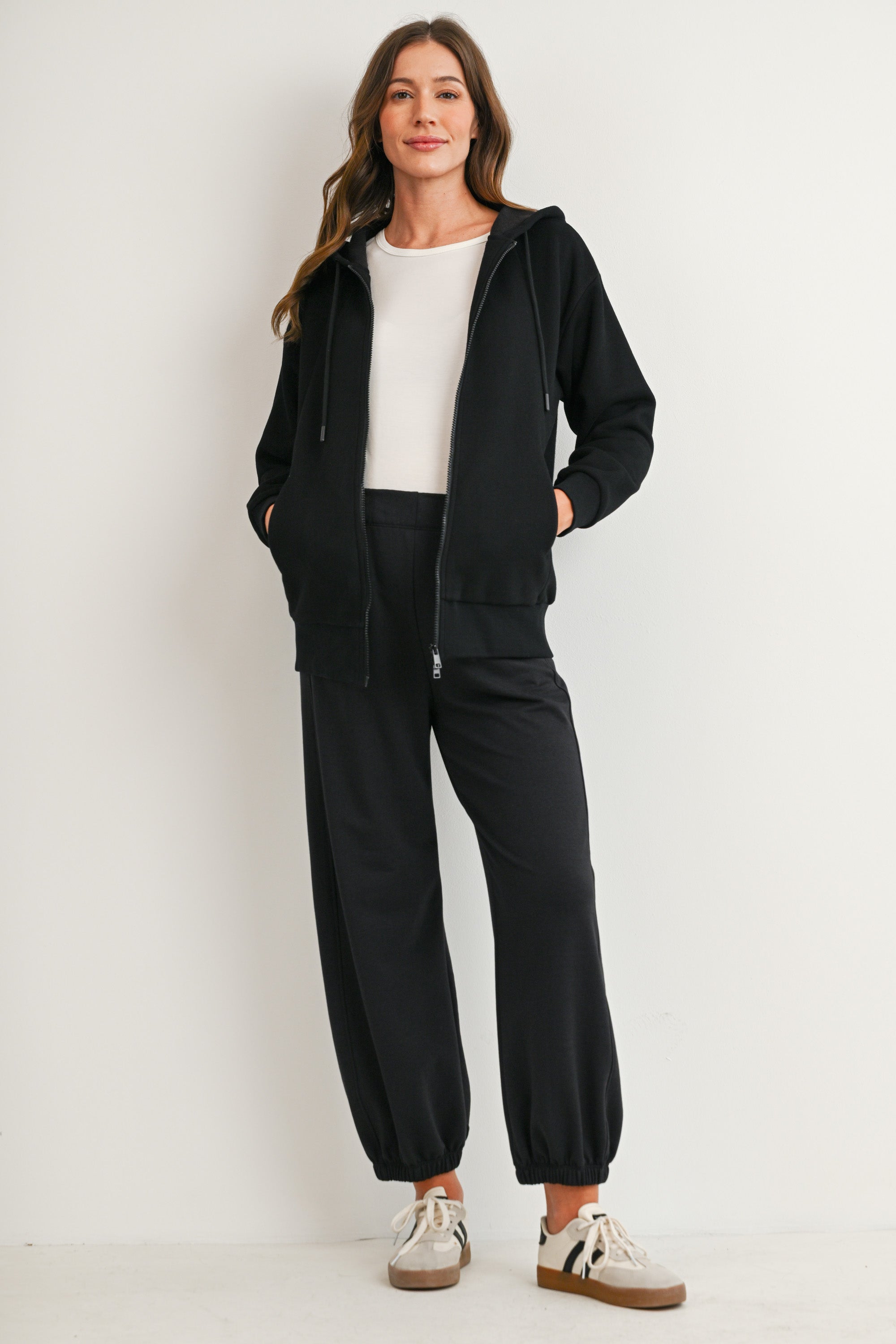 Full body view of black full-zip maternity hoodie with pockets and drawstring hood