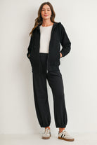 Full body view of black full-zip maternity hoodie with pockets and drawstring hood