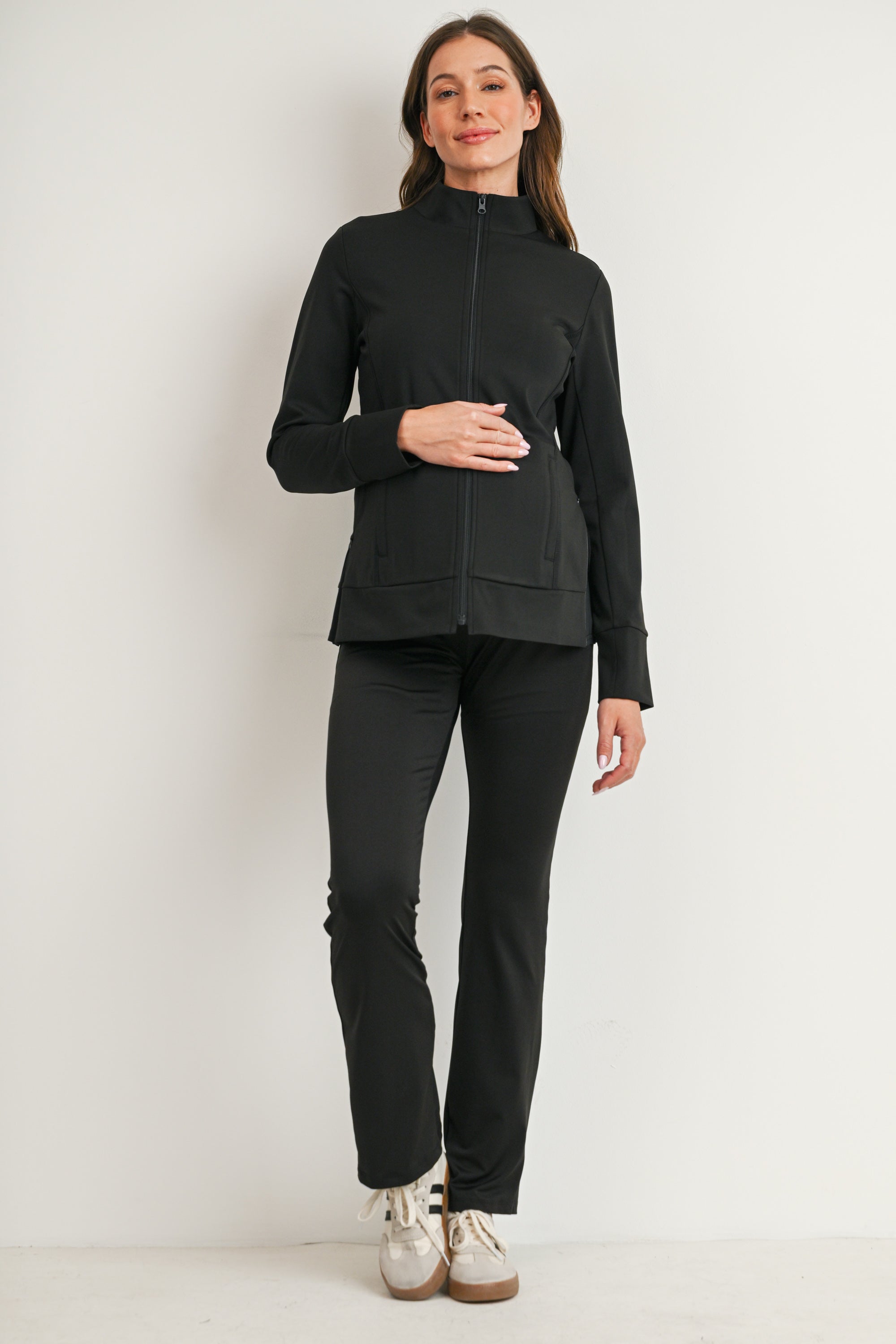 Full body view of black maternity full-zip jacket styled with pants